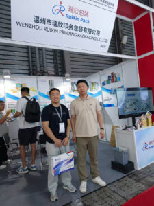 Ashton Li from Aocheng Metal meeting with a packaging supplier at Aluminium China 2026 to discuss aluminum foil packaging solutions.